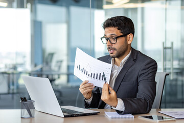 Serious successful businessman inside office on online video meeting presentation, man in business...