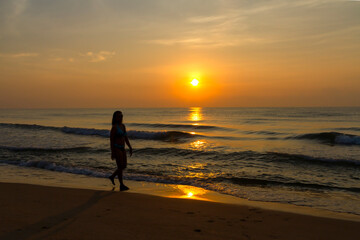 Naklejka premium Woman body big with bikini and sunrise on beach