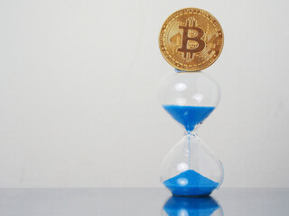 Golden bitcoin on blue sand clock. Time to invest into crypto currency concept. Economy and financial background.