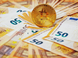 Golden bitcoin standing on euro bank notes. Time to invest into crypto currency concept. Economy and financial background. Get rich theme.