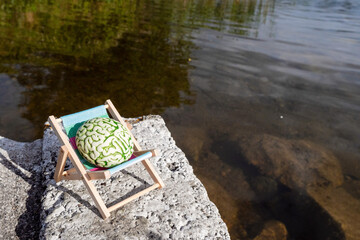 Brain on a sun bed in nature area. Positive effect of fresh air and sun on mind. Taking break from...