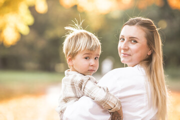 Mothers day, love family.  Family on autumn walk in nature outdoors. Mother and child with hugging tenderness