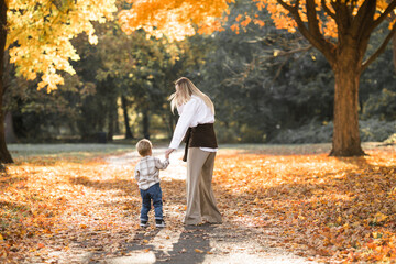 Fototapeta premium Mothers day, love family. Family on autumn walk in nature outdoors. Mother and child with hugging tenderness