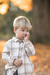 Autumn portrait of 2-3 years old child in garden. Fall season. Close-up view of cheerful sweet baby boy