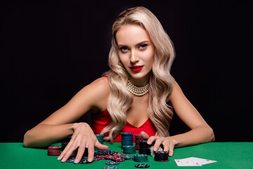 Photo of chic lady addicted poker player win every game hold collect chips on table over dark color...