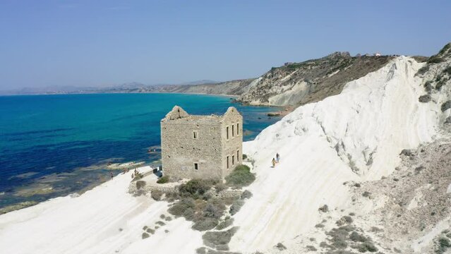Drone view in Punta Bianca, abandoned stone house on white cliffs in Sicily, aerial video in Agrigento. 