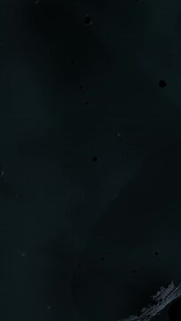 Asteroid belt field in dark outer space. 3D animation wide pan shot. Rock formations of cosmic debris and giant Meteorites. Celestial objects on starry stars background with dust nebula haze low light