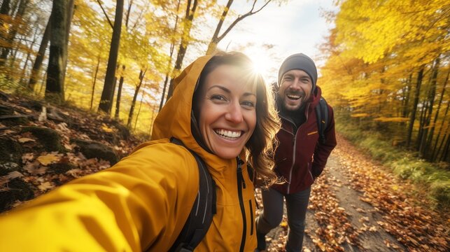 young couple in the forest in autumn making selfie or photo