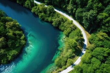 The road along the sea, lake and forest. View from above. A highway in middle of the forest.