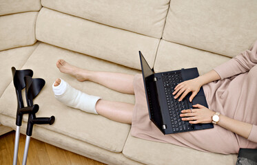 A woman is using her laptop to communicate with a doctor in an online session. Telehealth and...