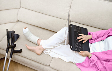Female employee with  broken leg working remotely. Online doctor-patient conversation with woman on...