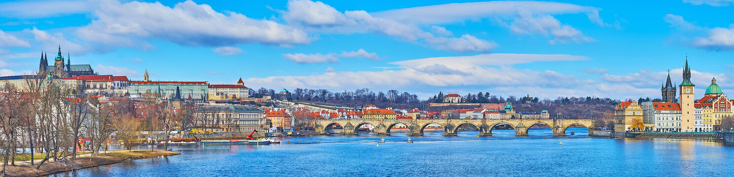 Panorama of deep blue Vltava River and Charles Bridge, Prague, Czechia