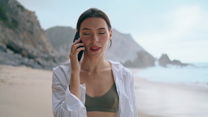 Girl talking smartphone seashore close up. Woman calling phone standing on beach