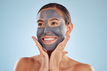 Woman, charcoal face mask and thinking of skincare, natural beauty and cosmetics benefits on studio, blue background. Happy person or model with facial collagen and healthy skin care for dermatology