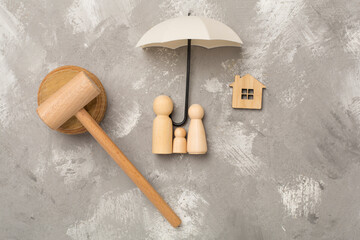 Wooden family figures with judge's gavel on concrete background,top view