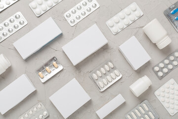 Flat lay with different pills in blister packaging and boxes and on concrete background