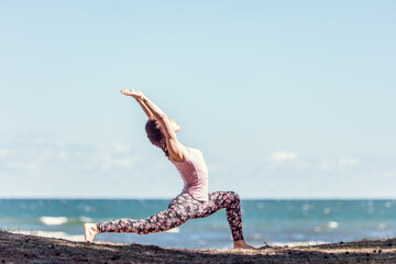 Young caucasian woman practicing yoga at seashore - 671874643
