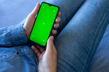 a person holding a phone with a green screen, is holding a smartphone
