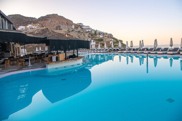 Fototapeta na wymiar Blue Pool near the building on a background of blue sky and sea in Greece.