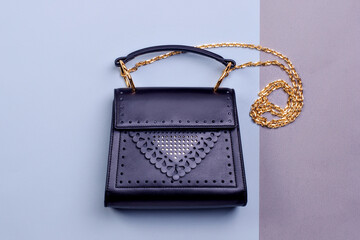 Elegant black leather woman's bag with original perforation design, gold shoulder chain, and top...