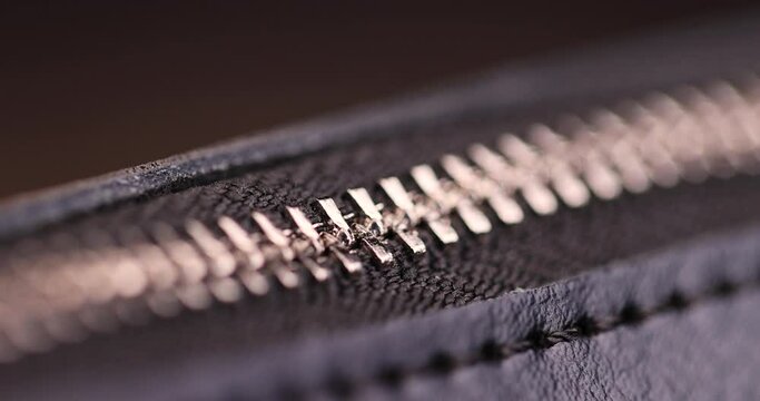 metal zipper on a black leather product, zipper on a black women's handbag close-up