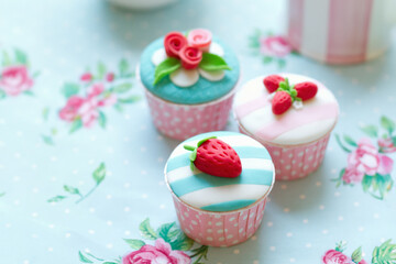 Cupcakes decorated with fondant strawberries and roses