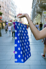 Happy young woman and shopping bags on city street