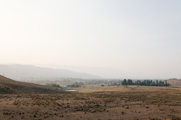 A picturesque highway among mountains and yellow dry grass on a sunny autumn day. Beautiful autumn panorama. California, USA in autumn