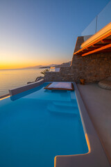 Infinity swimming pool in the villa at sunset time, Mykonos, Greece