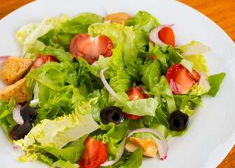 A fresh and vibrant salad featuring crisp lettuce, juicy tomatoes, black olives, red onions, and crunchy croutons. Perfect for food blogs, restaurant menus, or healthy lifestyle promotions
