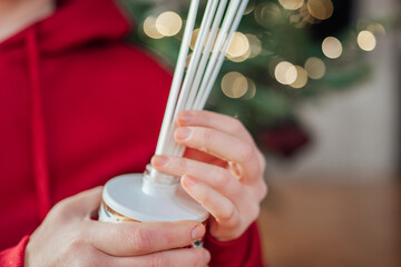Fragrance diffusers with the scents of Christmas.incense sticks in a hand on a Christmas tree...