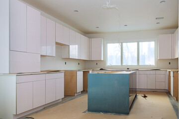 Fototapeta na wymiar Worktop installation custom kitchen cabinets white color in new home