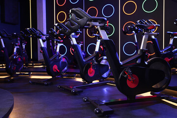 Many exercise bikes in fitness club. Indoor cycling class