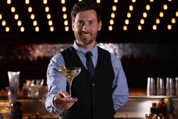 Bartender with fresh alcoholic cocktail in bar, selective focus