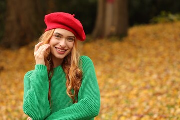 Portrait of smiling woman wearing autumn sweater outdoors. Space for text
