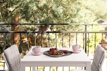 Outdoor breakfast with tea and croissants on white table on terrace