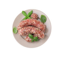 Plate of raw homemade sausages and basil leaves isolated on white, top view