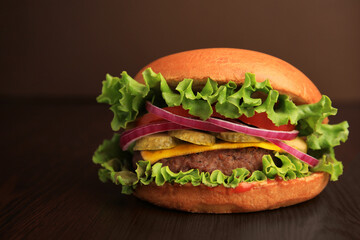 One tasty burger on wooden table, closeup