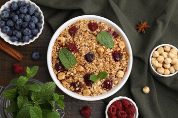 Tasty baked oatmeal with berries and nuts on wooden table, flat lay