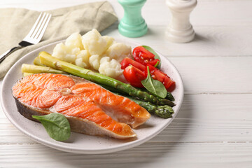 Healthy meal. Grilled salmon steak and vegetables served on white wooden table, closeup