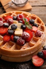 Tasty Belgian waffles with fresh berries, cheese and powdered sugar on table, closeup