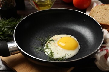 Delicious fried egg in frying paan on wooden table, closeup