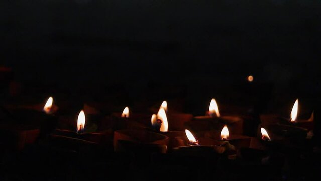 Diya or earthen oil lamps burning with glowing yellow flame during Diwali festival of india. These are made of clay and considered as auspicious element during puja.