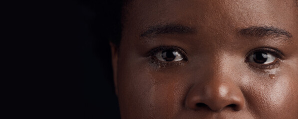 Black woman, eyes and mental health, crying with depression and crisis with abuse on dark...