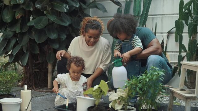 Happy African American family enjoying gardening at home