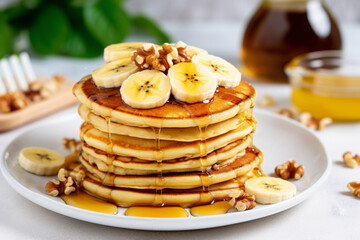 Stack of homemade pancakes for breakfast with banana and walnuts
