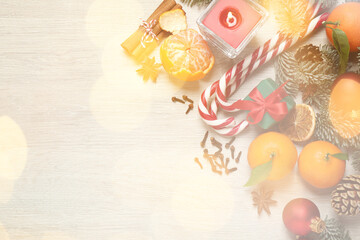 Beautiful Christmas composition with candy canes, tangerines and space for text on white wooden table, flat lay. Bokeh effect
