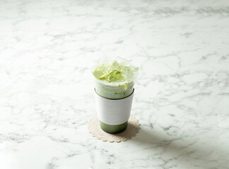 Iced green tea latte in a take-out cup	