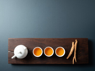 Dried  ginseng and hot tea on tea table - obrazy, fototapety, plakaty