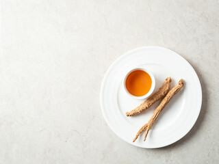 Dried ginseng and hot tea on a plate